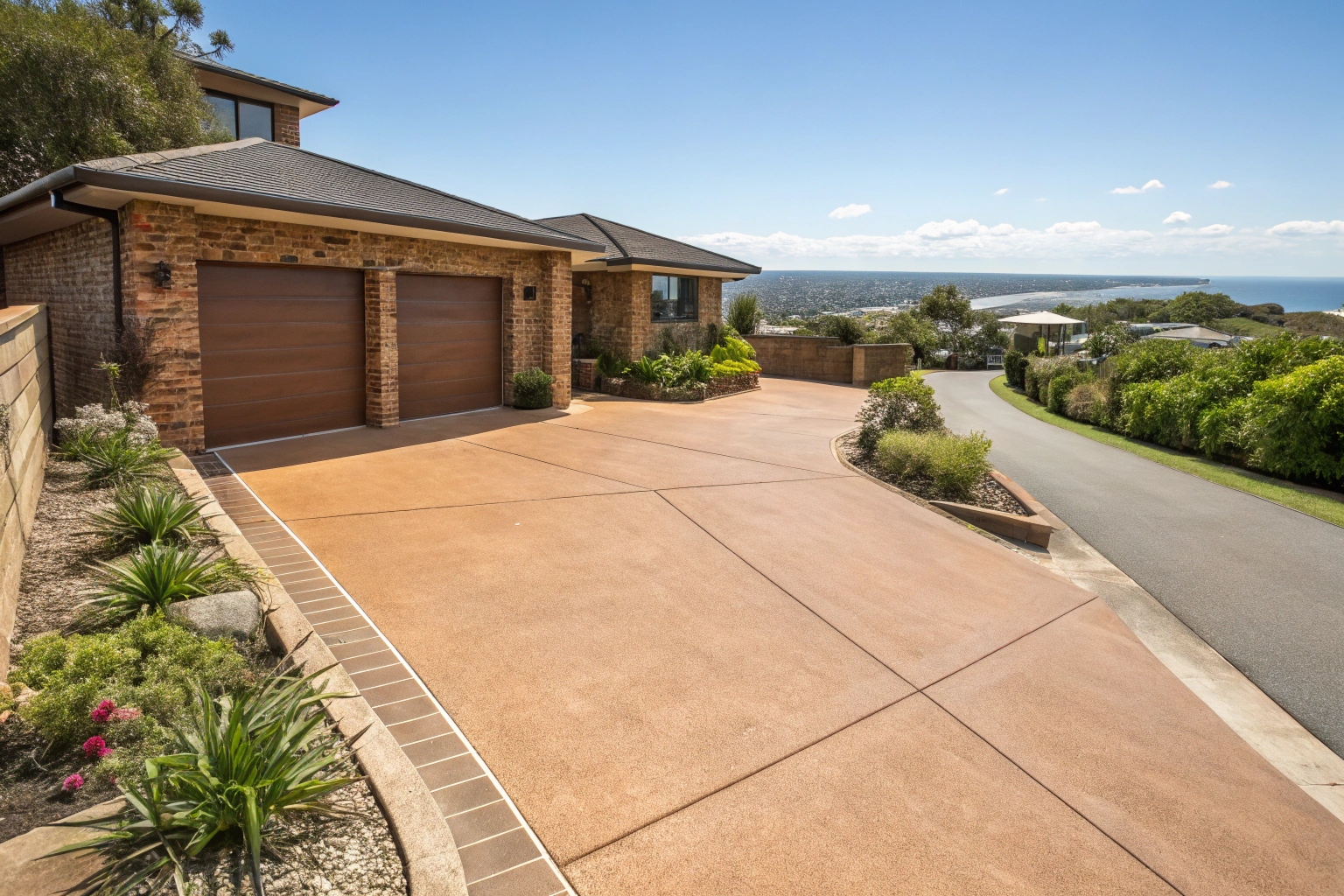 Coloured concrete driveway with sandstone finish at a coastal Australian home